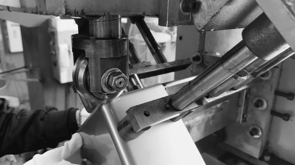 Close-up of specialized machinery with red tubing and mechanical components used in sanitary ware production